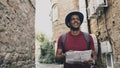 African american tourist man walking and watching paper city map to find directions to famous place Royalty Free Stock Photo