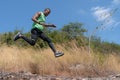 African american trail runner running on trail in natural mountain