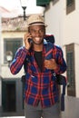 African american travel man smiling with backpack and talking with mobile phone Royalty Free Stock Photo