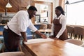 African American Waiter Teaching Female Employee How To Fold Tablecloth Royalty Free Stock Photo