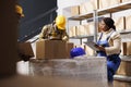 African american warehouse manager controlling assistant packing cardboard box Royalty Free Stock Photo