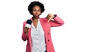 African american woman with afro hair holding reporter microphone with angry face, negative sign showing dislike with thumbs down, Royalty Free Stock Photo