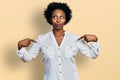 African american woman with afro hair pointing with fingers to herself smiling looking to the side and staring away thinking Royalty Free Stock Photo
