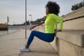 African-American woman with afro hair and sportswear, with fluorescent yellow sweatshirt and leggings, doing triceps exercises on Royalty Free Stock Photo