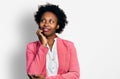 African american woman with afro hair wearing business jacket with hand on chin thinking about question, pensive expression