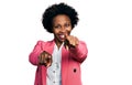 African american woman with afro hair wearing business jacket pointing to you and the camera with fingers, smiling positive and Royalty Free Stock Photo