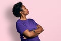 African american woman with afro hair wearing casual purple t shirt looking to the side with arms crossed convinced and confident Royalty Free Stock Photo