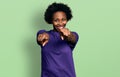 African american woman with afro hair wearing casual purple t shirt pointing to you and the camera with fingers, smiling positive Royalty Free Stock Photo