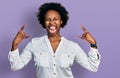 African american woman with afro hair wearing casual white t shirt shouting with crazy expression doing rock symbol with hands up Royalty Free Stock Photo