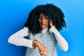 African american woman with afro hair wearing casual winter sweater looking at the watch time worried, afraid of getting late Royalty Free Stock Photo