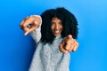 African american woman with afro hair wearing casual winter sweater pointing to you and the camera with fingers, smiling positive Royalty Free Stock Photo