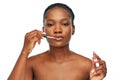 African american woman applying lip gloss Royalty Free Stock Photo