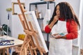 African american woman artist looking draw with doubt expression at art studio