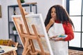 African american woman artist looking draw with doubt expression at art studio