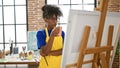 African american woman artist looking draw holding cup of coffee at art studio