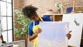 African american woman artist smiling confident holding draw at art studio