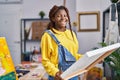 African american woman artist smiling confident looking draw at art studio