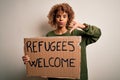 African american woman asking for immigration holding banner with wlecome refugees message with angry face, negative sign showing Royalty Free Stock Photo