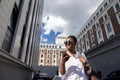 African american woman with backpack walking outdoor and talking on mobile phone Royalty Free Stock Photo