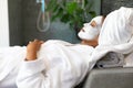 African american woman in a bathrobe with facial beauty mask relaxing at home Royalty Free Stock Photo