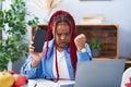 African american woman with braided hair holding smartphone showing blank screen annoyed and frustrated shouting with anger, Royalty Free Stock Photo