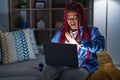 African american woman with braided hair using computer laptop at night doing stop gesture with hands palms, angry and frustration Royalty Free Stock Photo