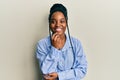 African american woman with braided hair wearing casual blue shirt smiling looking confident at the camera with crossed arms and Royalty Free Stock Photo