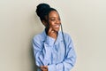 African american woman with braided hair wearing casual blue shirt thinking concentrated about doubt with finger on chin and Royalty Free Stock Photo