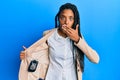 African american woman with braids showing detective badge covering mouth with hand, shocked and afraid for mistake Royalty Free Stock Photo