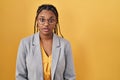 African american woman with braids standing over yellow background afraid and shocked with surprise expression, fear and excited Royalty Free Stock Photo