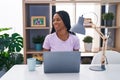 African american woman with braids using laptop at home looking away to side with smile on face, natural expression Royalty Free Stock Photo