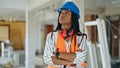 African american woman builder standing with arms crossed gesture and serious expression at construction site Royalty Free Stock Photo