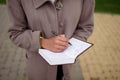 African-american woman in business clothes with a notepad conducts an interview, close-up