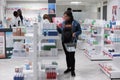 African american woman checking prescription heart supplements in drugstore