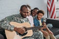 African american woman and children listening to father in camouflage clothes