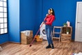 African american woman cleaning floor singing at laundry room Royalty Free Stock Photo