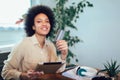 African american woman with digital tablet and credit card in home office. Royalty Free Stock Photo