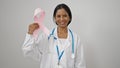 African american woman doctor holding breast cancer awareness pink ribbon over isolated white background Royalty Free Stock Photo