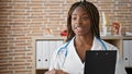 African american woman doctor holding medical report speaking at the clinic Royalty Free Stock Photo