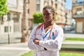 African american woman doctor standing with arms crossed gesture and serious expression at park Royalty Free Stock Photo