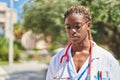 African american woman doctor standing with serious expression at park Royalty Free Stock Photo