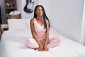 African american woman doing yoga exercise meditating on bed at bedroom Royalty Free Stock Photo