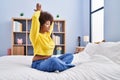 African american woman doing yoga exercise sitting on bed at bedroom Royalty Free Stock Photo