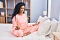 African american woman doing yoga exercise sitting on bed at bedroom Royalty Free Stock Photo