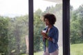 African American woman drinking coffee looking out the window Royalty Free Stock Photo