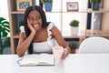 African american woman drinking coffee reading book at home Royalty Free Stock Photo