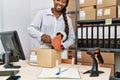 African american woman ecommerce business worker packing cardboard box at office Royalty Free Stock Photo