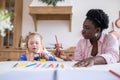 African american woman and a girl learning colors and drawing