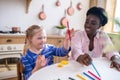 African american woman and a girl learning colors and drawing