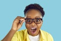 African American woman in glasses looking at something with happy, surprised face expression Royalty Free Stock Photo